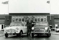 Issigonis ved siden av den frste Minien og en 1965 modell utenfor fabrikken i Longbridge. Klikk for  se strre bilde.